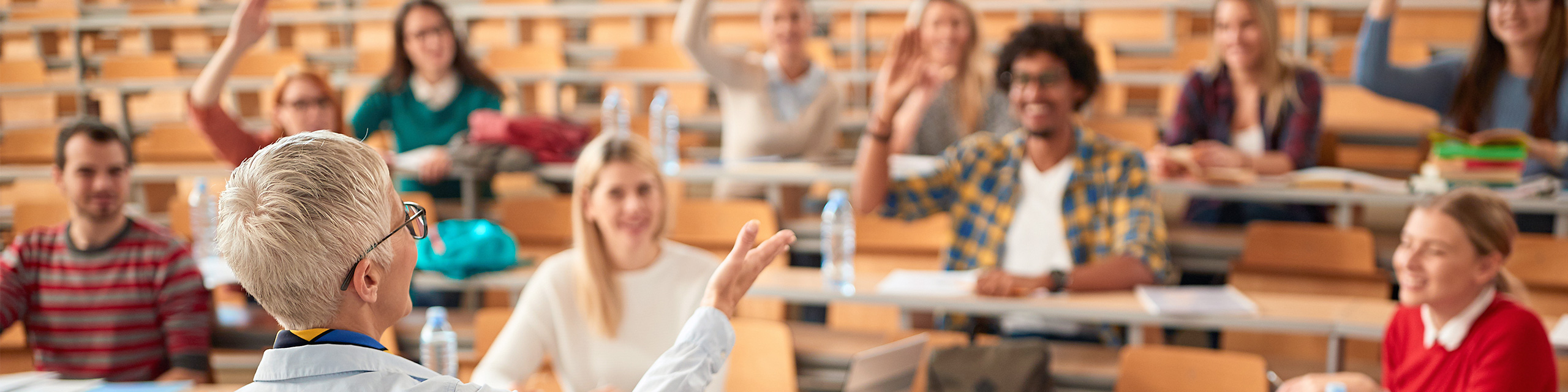 instructor in front of a classroom full of raised hands