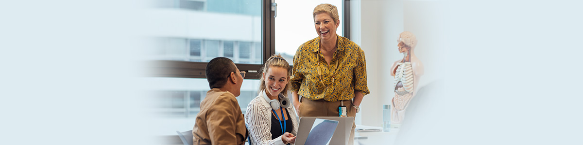 Teacher assisting group of students in classroom